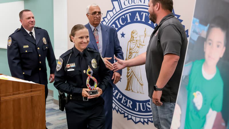 Sandy Police Detective Cori Biggs looks at a photo of 6-year-old Norlin Cruz after receiving the Community Justice Award from Salt Lake County District Attorney Sim Gill at the District Attorney’s Office in Salt Lake City on Thursday, June 22, 2023. Biggs was honored for her work in investigating the child abuse homicide case resulting from the death of Cruz.