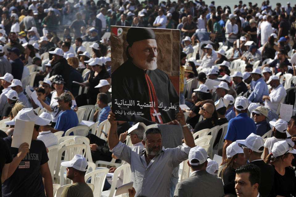 A mourner holds up a picture of former Maronite Patriarch Cardinal Mar Nasrallah Boutros Sfeir, during his funeral Mass, at the seat of the Maronite Church, in the village of Bkirki, north of Beirut, Lebanon, Thursday, May 16, 2019. Sfeir, who served as spiritual leader of Lebanon's largest Christian community through some of the worst days of the country's 1975-1990 civil war, died Sunday. (AP Photo/Bilal Hussein)