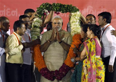 Hindu nationalist Narendra Modi, who will be the next prime minister of India, wears a garland presented to him by his supporters at a public meeting in the western Indian city of Ahmedabad May 20, 2014. REUTERS/Amit Dave