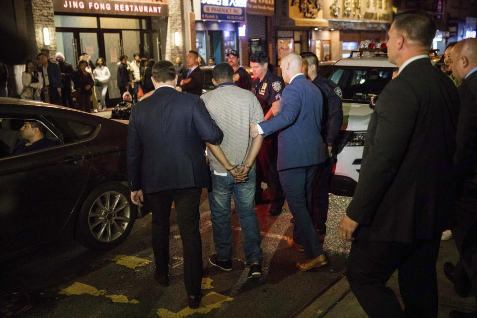 Police officers escort Randy Rodriguez Santos from the 5th Precinct to a vehicle bound for a hospital for evidence collection, Saturday, Oct. 5, 2019, in New York. Santos was arrested in connection with the deaths of several homeless men. (AP Photo/Julius Constantine Motal)
