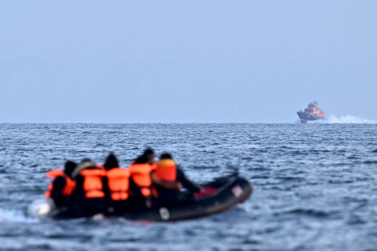 Stock photo shows a rescue boat making its way towards migrants travelling in an inflatable boat across the English Channel (AFP via Getty Images)