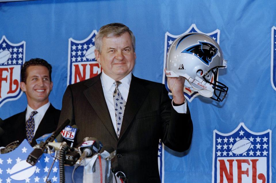 Jerry Richardson shows off his new team's helmet as the Carolina Panthers became the newest NFL franchise after commissioner Paul Tagliabue made the announcement during the league's expansion meeting in Rosemont, Ill., Oct. 26, 1993. Mark Richardson, Jerry's son, is at left. [AP Photo/Mark Elias]