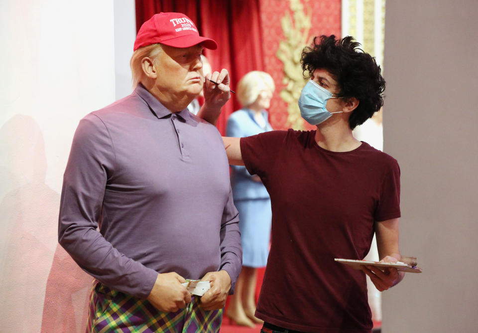 A member of the Madame Tussauds studios team adjusts a wax figure of Donald Trump which has been re-dressed in golf wear following the 2020 US presidential election, after Joe Biden's third bid for the White House has been a success as he is set to become the 46th President of the United States. (Photo by Jonathan Brady/PA Images via Getty Images)