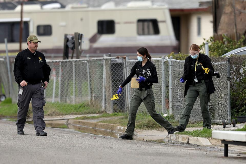 Sheriff's officials holding evidence outside a residence