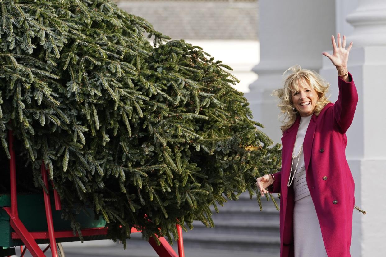 First lady Jill Biden waves as she looks over the arrival of the White House Christmas tree on Monday, Nov. 22, 2021. 