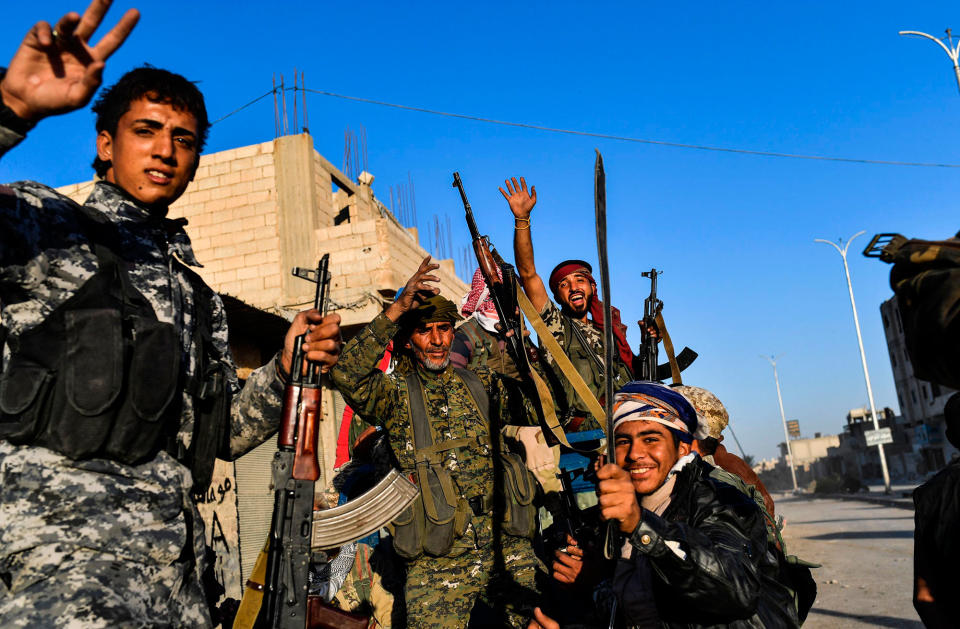 <p>Members of the Syrian Democratic Forces (SDF), backed by US special forces, celebrate at the frontline in the Islamic State (IS) group jihadists crumbling stronghold of Raqa on Oct. 16, 2017. (Photo: Bulent Kilic/AFP/Getty Images) </p>