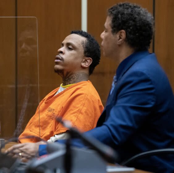 Eric Holder Jr., left, listens during his sentencing proceeding for the murder of Nipsey Hussle in Superior Court.