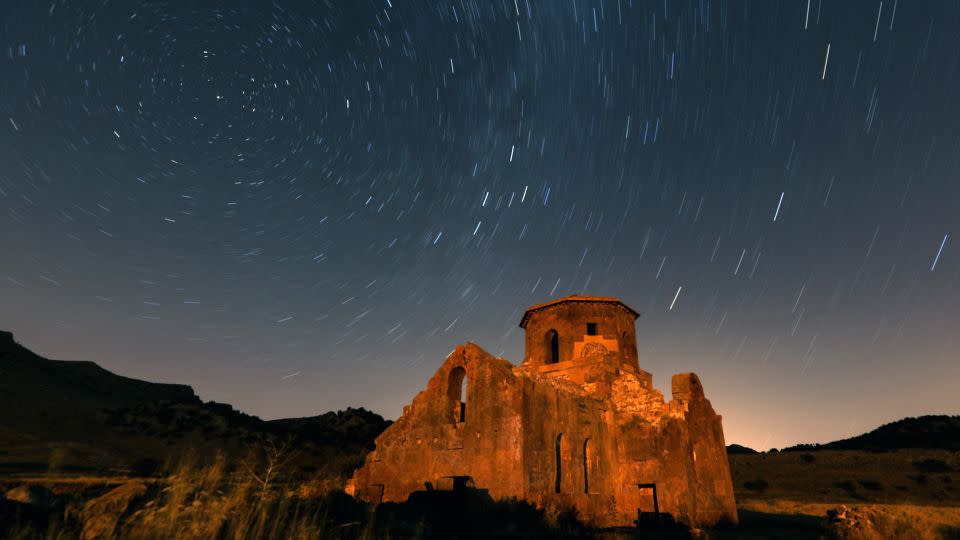 A long exposure photo shows the Perseid meteor shower over the Red Church and Guzelyurt Monastery Valley in Turkey on August 12, 2023. - Aytug Can Sencar/Anadolu Agency/Getty Images