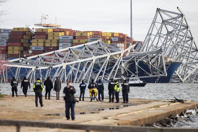 <p>JIM LO SCALZO/EPA-EFE/Shutterstock</p> Rescue personnel gather on the shore of the Patapsco River after a container ship ran into the Francis Scott Key Bridge in Baltimore, Maryland on March 26, 2024