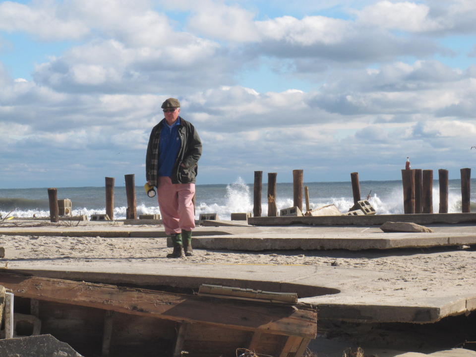 In this Oct. 31, 2012 photo, Peter Green surveys the wreckage of an oceanfront home in Bay Head N.J. two days after Superstorm Sandy hit. Ten years later, government officials and residents say much has been done to prepare for future storms but caution that much more still remains to be done in an era of rising sea levels and a changing climate. (AP Photo/Wayne Parry)