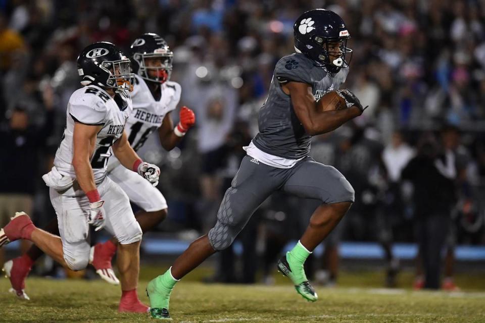 Millbrook’s Nathan Leacock (15) sprints for the touchdown ahead of Heritage’s Coleson Fields (22) in the second half. The Millbrook Wildcats and the Heritage Huskies met in a football game in Raleigh, N.C. on September 29, 2022.