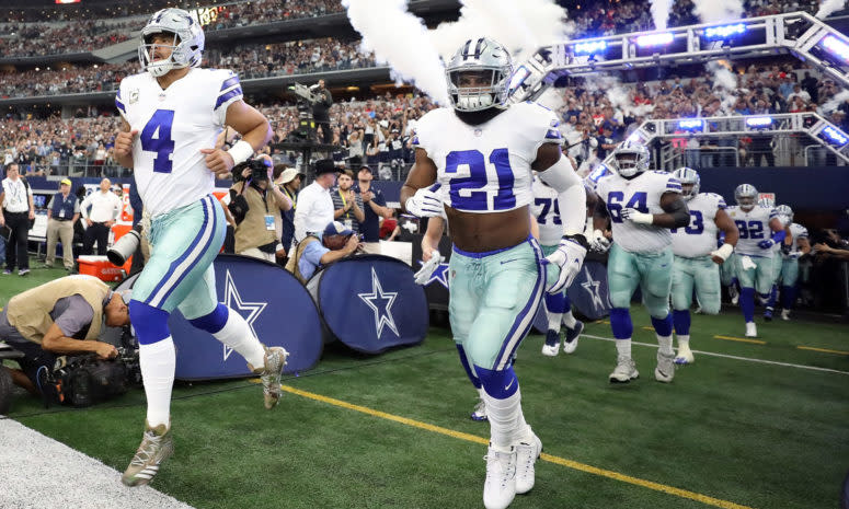 The Dallas Cowboys run onto the field before a game at AT&T Stadium.