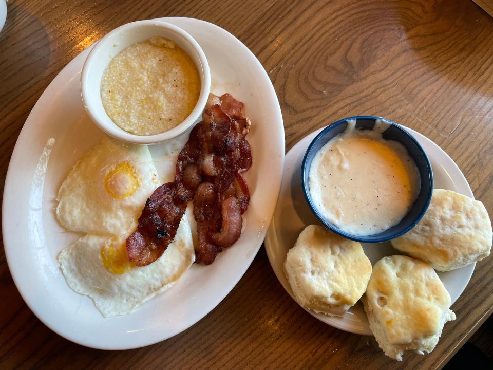 Old Timer's Breakfast at Cracker Barrel, which includes grits, over-easy eggs, and bacon and another plate of biscuits and gravy