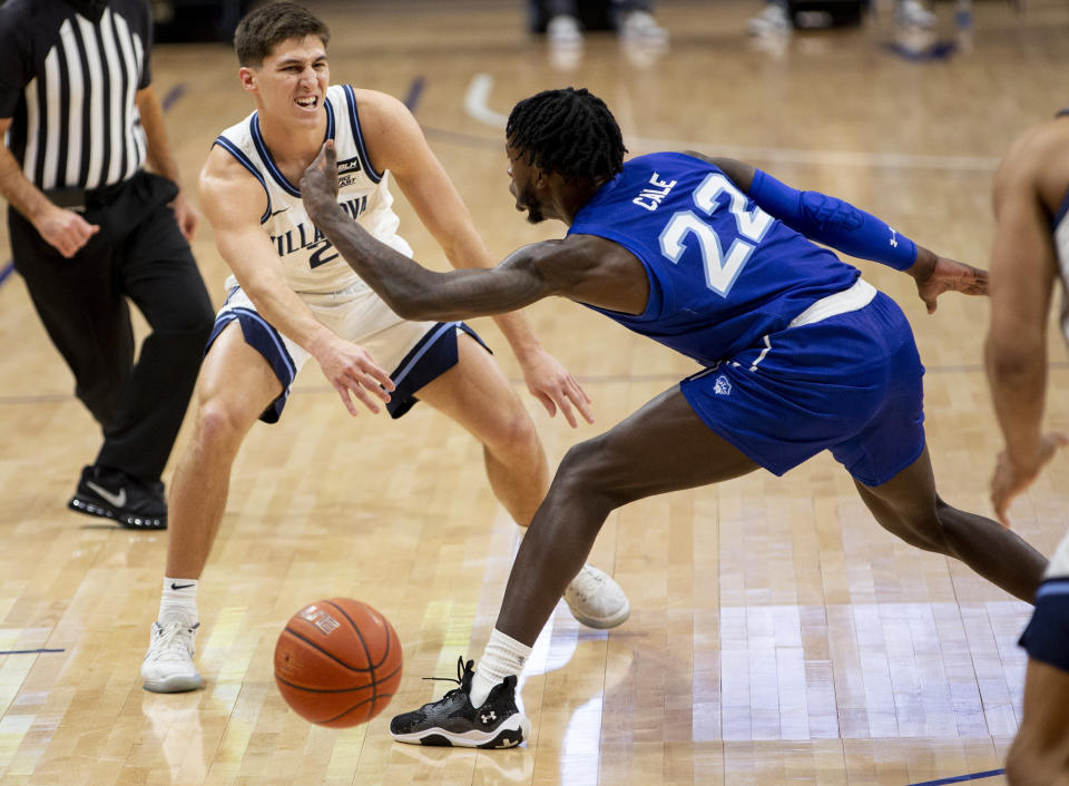 Villanova guard Collin Gillespie (2) passes the ball past Seton Hall guard Myles Cale (22) during the first half of an NCAA college basketball game, Tuesday, Jan. 19, 2021, in Villanova, Pa. (AP Photo/Laurence Kesterson)