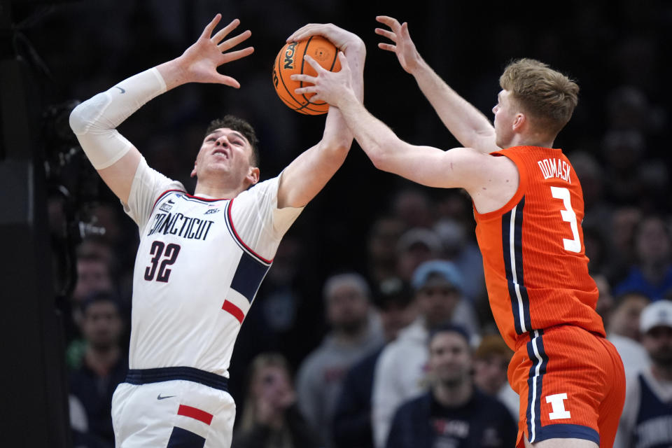 UConn center Donovan Clingan (32) grabs a rebound against Illinois forward Marcus Domask (3) during the second half of the Elite 8 college basketball game in the men's NCAA Tournament, Saturday, March 30, 2024, in Boston. (AP Photo/Steven Senne)