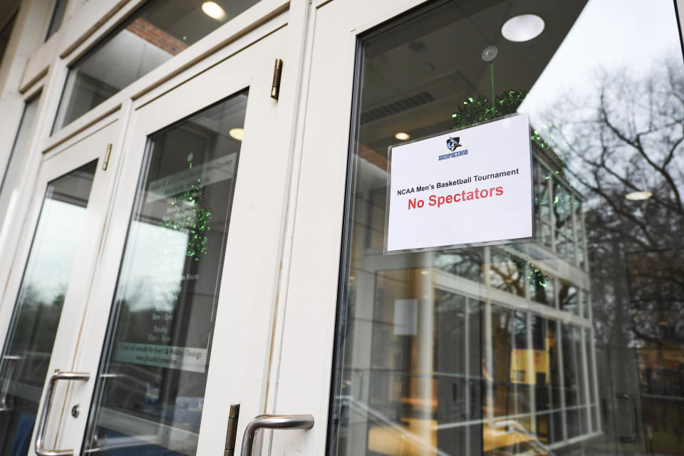 A no spectators sign is tapped to a door at Goldfarb Gymnasium on the campus of Johns Hopkins University before a first-round game at the men's Division III NCAA college basketball tournament, between Worcester Polytechnic Institute and Yeshiva University, Friday, March 6, 2020, in Baltimore. The university held the tournament without spectators after cases of COVID-19 were confirmed in Maryland. (AP Photo/Terrance Williams)