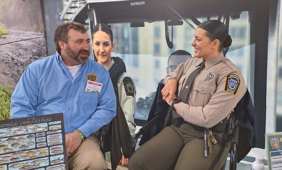 Pennsylvania Fish and Boat Commission staff members Joe Tusing and Rachael Thurner-Diaz talk Sunday at the Great American Outdoor Show in Harrisburg about fishing.