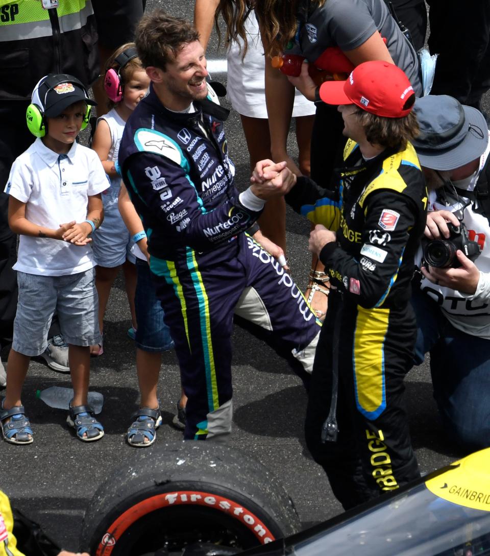 Dale Coyne Racing with RWR driver Romain Grosjean (51) and Andretti Autosport with Curb-Agajanian driver Colton Herta (26) congratulate each other after finishing second and third Saturday, Aug. 14, 2021, during the Big Machine Spiked Coolers Grand Prix at Indianapolis Motor Speedway. 