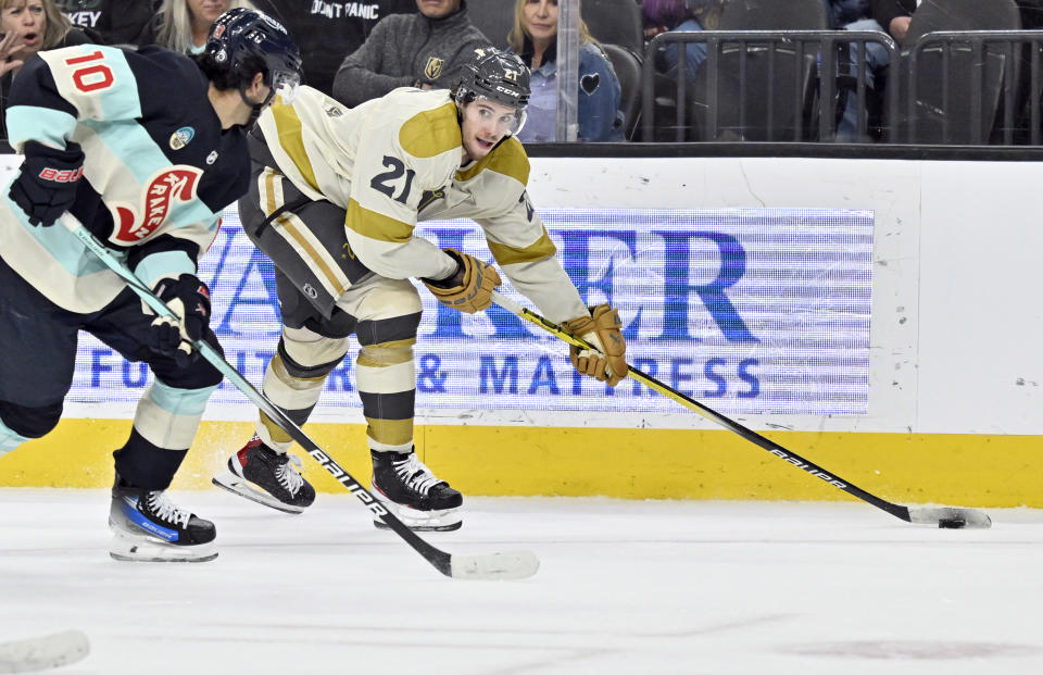 Vegas Golden Knights center Brett Howden (21) looks to pass the puck against Seattle Kraken center Matty Beniers (10) during the second period of an NHL hockey game Thursday, March 21, 2024, in Las Vegas. (AP Photo/David Becker)