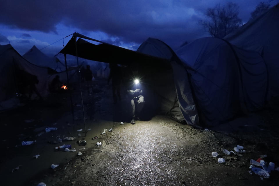 In this photo taken Wednesday, Nov. 13, 2019, a migrant walks in the Vucjak refugee camp outside Bihac, northwestern Bosnia. The European Union's top migration official is warning Bosnian authorities of a likely humanitarian crisis this winter due to appalling conditions in overcrowded migrant camps in the country. (AP Photo/Darko Vojinovic)