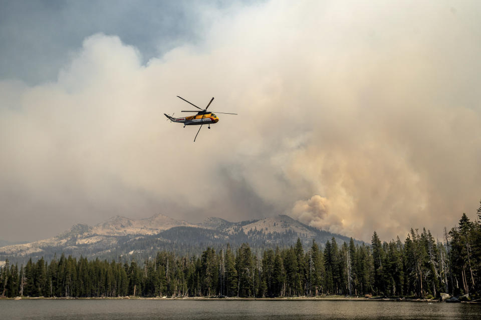 A helicopter flies over Wrights Lake while battling the Caldor Fire in Eldorado National Forest, Calif. on Wednesday, Sept. 1, 2021. (AP Photo/Noah Berger)