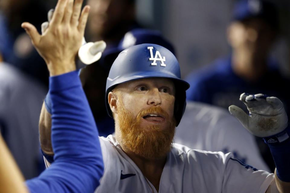 El tercera base de los Dodgers, Justin Turner, celebra con sus compañeros en el banquillo.