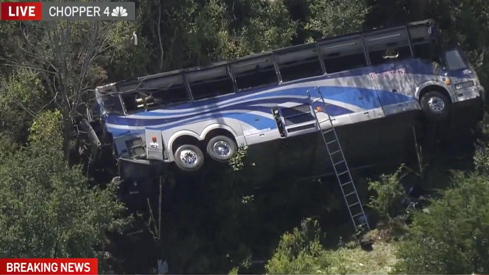 A bus lies on its side where it crashed along Interstate 84, in Wawayanda, N.Y., Thursday, Sept. 21, 2023. The charter bus carrying high school students to a band camp hurtled off the New York highway and down an embankment, officials said. (NBC New York via AP)