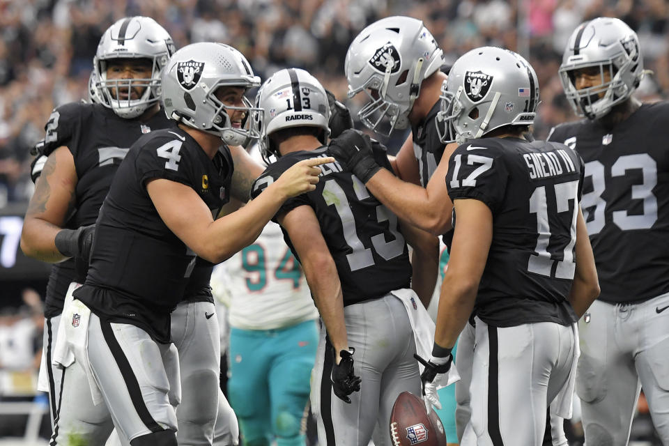 Las Vegas Raiders quarterback Derek Carr (4) celebrates after wide receiver Hunter Renfrow (13) scored a touchdown against the Miami Dolphins during the second half of an NFL football game, Sunday, Sept. 26, 2021, in Las Vegas. (AP Photo/David Becker)