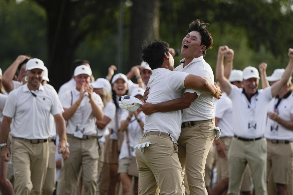 Tom Kim, of South Korea, left embraces teammate Si Woo Kim, of South Korea, after they won on the 18th hole during their fourball match at the Presidents Cup golf tournament at the Quail Hollow Club, Saturday, Sept. 24, 2022, in Charlotte, N.C. (AP Photo/Chris Carlson)