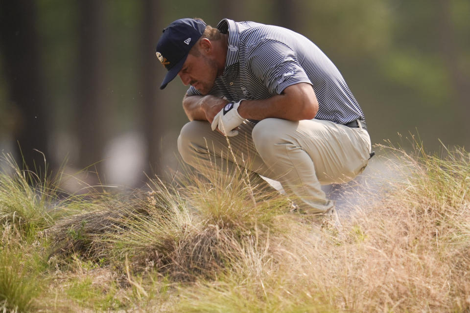 Bryson DeChambeau looks at his ball in the native area on the 12th hole during the final round of the U.S. Open golf tournament Sunday, June 16, 2024, in Pinehurst, N.C. (AP Photo/George Walker IV)