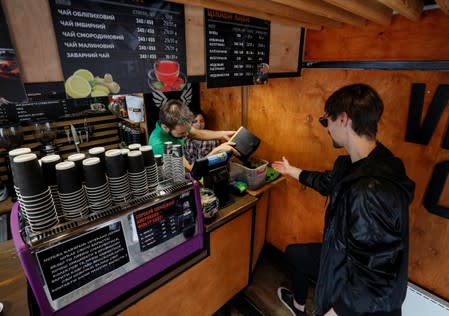 Havrylenko, CEO of innovative OCHIS COFFEE eyewear brand, picks up coffee waste in a cafe in Kiev