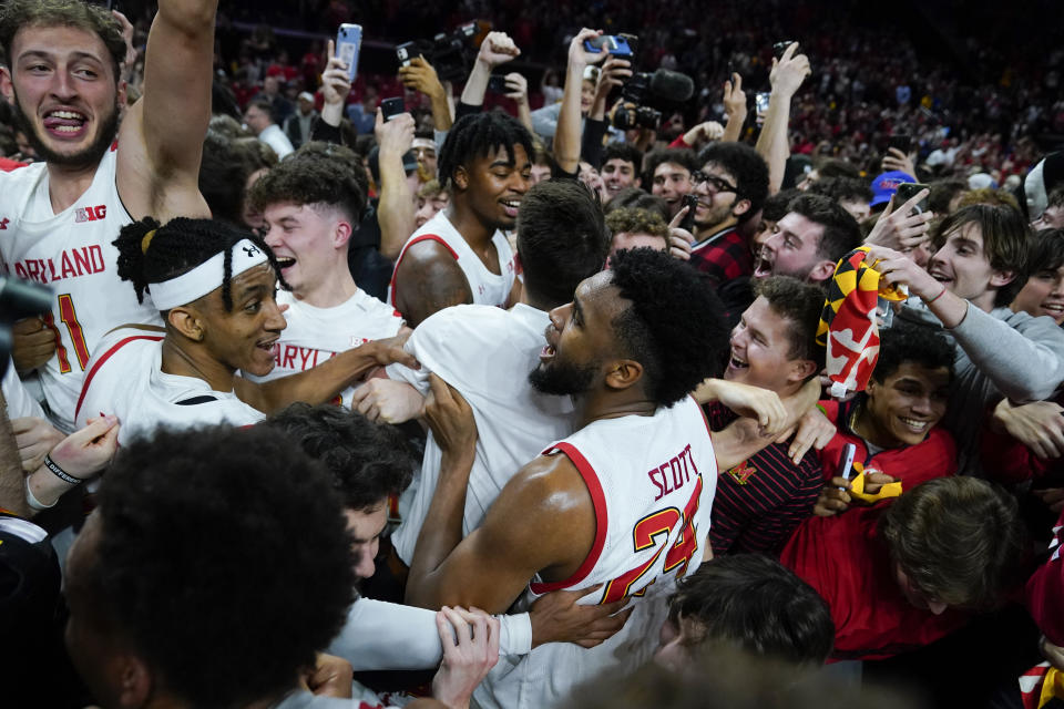 Maryland forward Donta Scott, center, and teammates are swarmed by students rushing the court after Maryland defeated Purdue 68-54 during an NCAA college basketball game, Thursday, Feb. 16, 2023, in College Park, Md. (AP Photo/Julio Cortez)