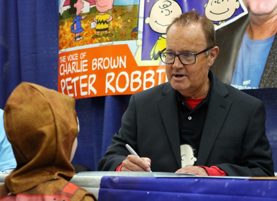 Peter Robbins, who voiced the title character in 1965's "A Charlie Brown Christmas," talks to a young fan while signing an autograph at Rhode Island Comic Con.