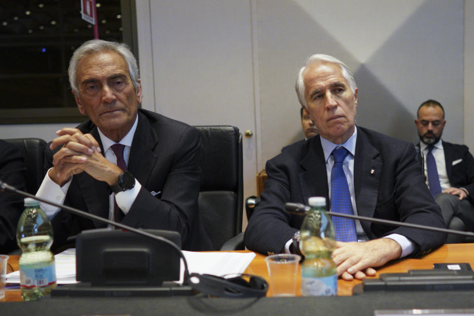 FILE - In this Monday, Jan. 7, 2019 file photo, Italian Soccer Federation President Gabriele Gravina, left, and CONI Olympic Committee President Giovanni Malago' attend a meeting on violence during soccer matches, in Rome. The Italian soccer federation is considering employing an advanced listening device used in anti-terrorism operations to identify fans who sing racist chants. Federation president Gabriele Gravina has detailed “a passive radar device that uses directional microphones to determine the source of the noise.” (AP Photo/Andrew Medichini, File)