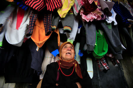 A Syrian woman talks under hanged laundry at a compound housing Syrian refugees in Sidon, southern Lebanon January 25, 2017. REUTERS/Ali Hashisho