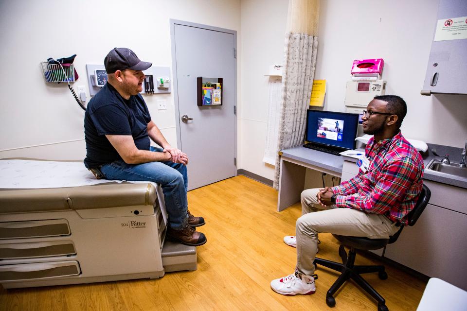 Carey Reeder gets information on free clinics from first-year medical student Randall Proctor during the UF Equal Access Clinic Student-Alumni Health Fair in 2019.