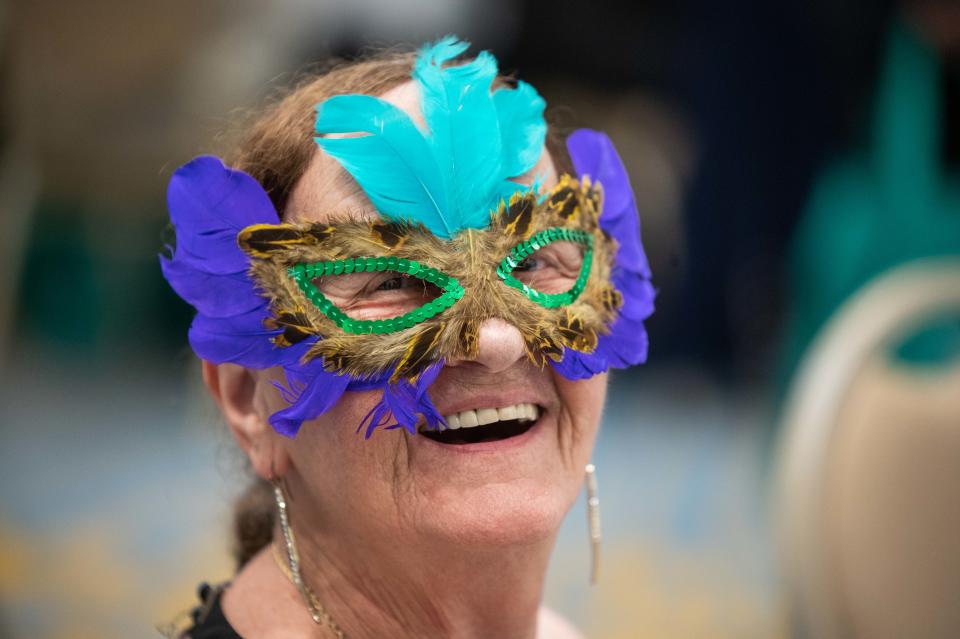 Linda Catron, Loxahatchee, smiles for a picture while wearing a mask decorated with feathers during a 'Young At Heart' prom for seniors held at the the Royal Palm Beach Cultural Center on Friday, May 26, 2023, in Royal Palm Beach, Fla.