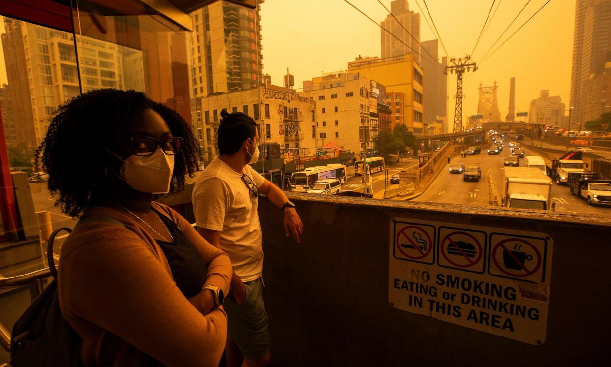 <span>People wait for the tramway to Roosevelt Island beneath smoke from Canadian wildfires, in New York City on 7 June 2023.</span><span>Photograph: Eduardo Muñoz/Getty Images</span>