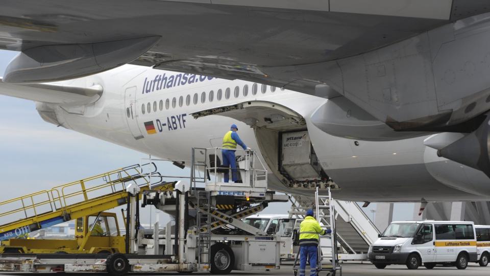 Arbeiter entladen auf dem Flughafen in Frankfurt/Main Fracht aus dem Laderaum eines Flugzeugs. Foto: Valentin Gensch/Archiv