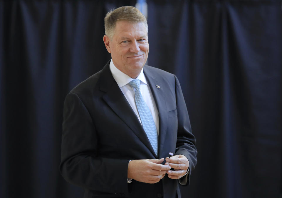 Romanian President Klaus Iohannis smiles after casting his vote in Bucharest, Romania, Sunday, Nov. 10, 2019. Voting got underway in Romania's presidential election after a lackluster campaign overshadowed by a political crisis which saw a minority government installed just a few days ago. (AP Photo/Vadim Ghirda)