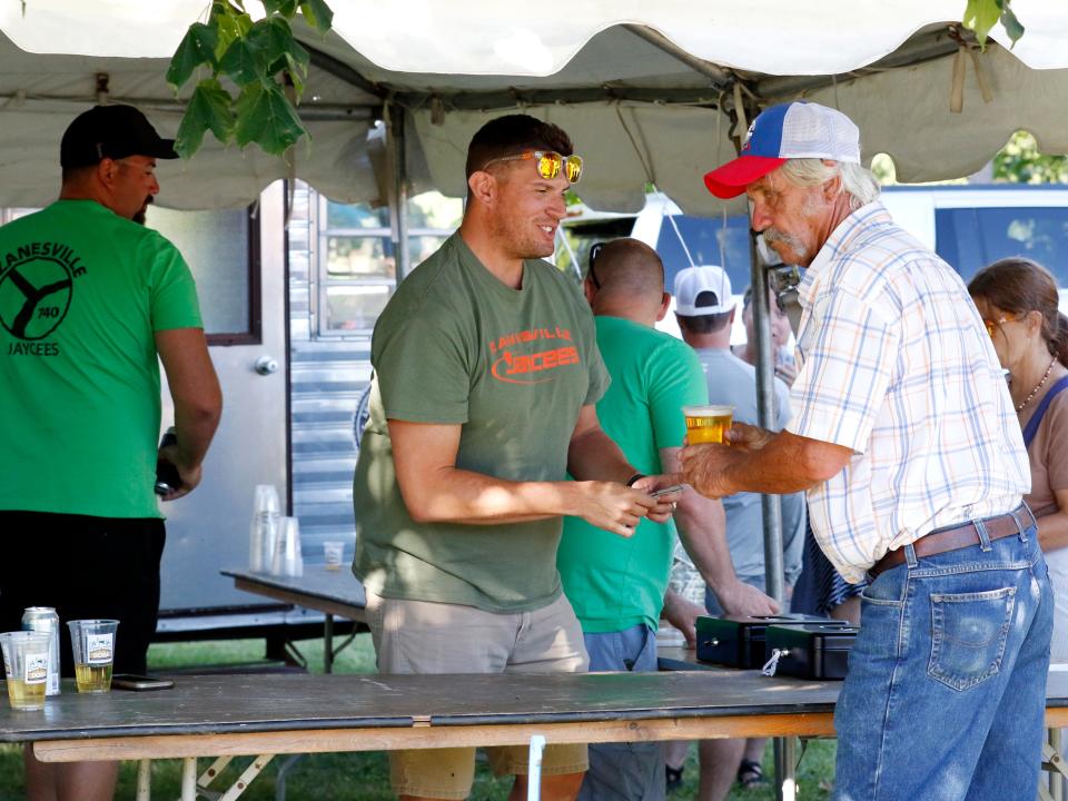 Taylor Russell, of the Zanesville Jaycees, serves beer to a customer on Saturday at Putnam Landing Park during the 2022 Zane's Trace Commemoration in downtown Zanesville. The event returns to Muskingum County this year on June 16 to18.