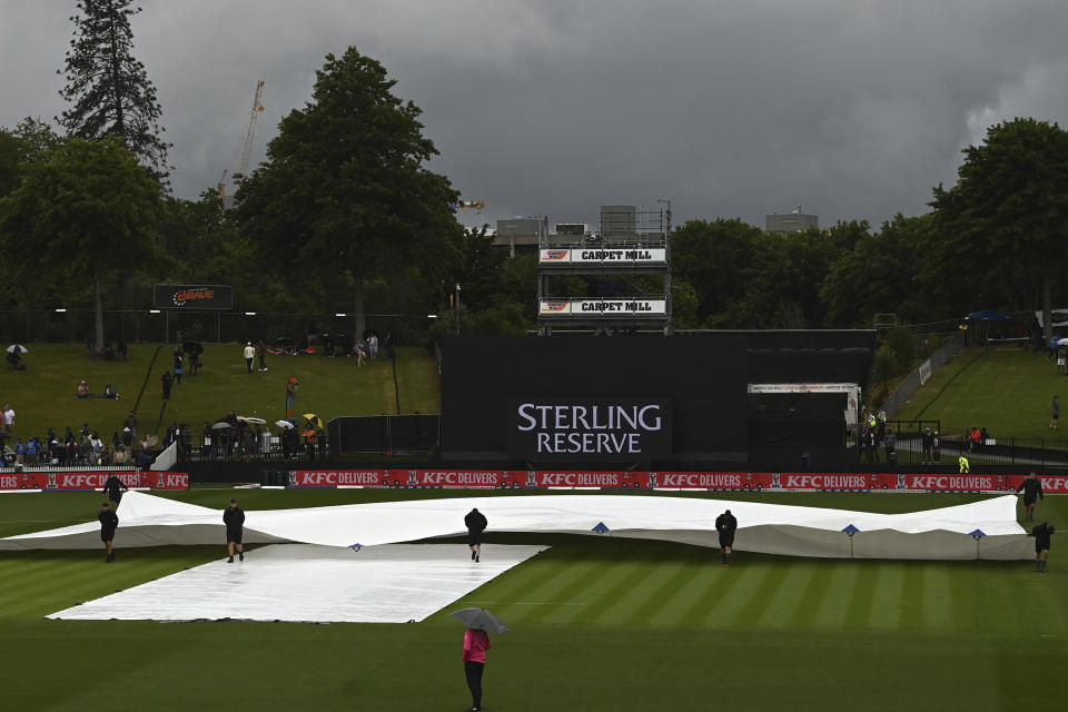 Ground staff pull covers onto the wicket during a rain delay in a one day international cricket match between India and New Zealand in Hamilton, New Zealand, Sunday, Nov. 27, 2022. (Andrew Cornaga/Photosport via AP)