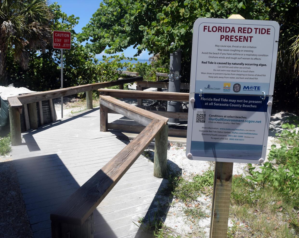 A sign warns of red tide at a Sarasota County beach on Aug. 20, 2018.