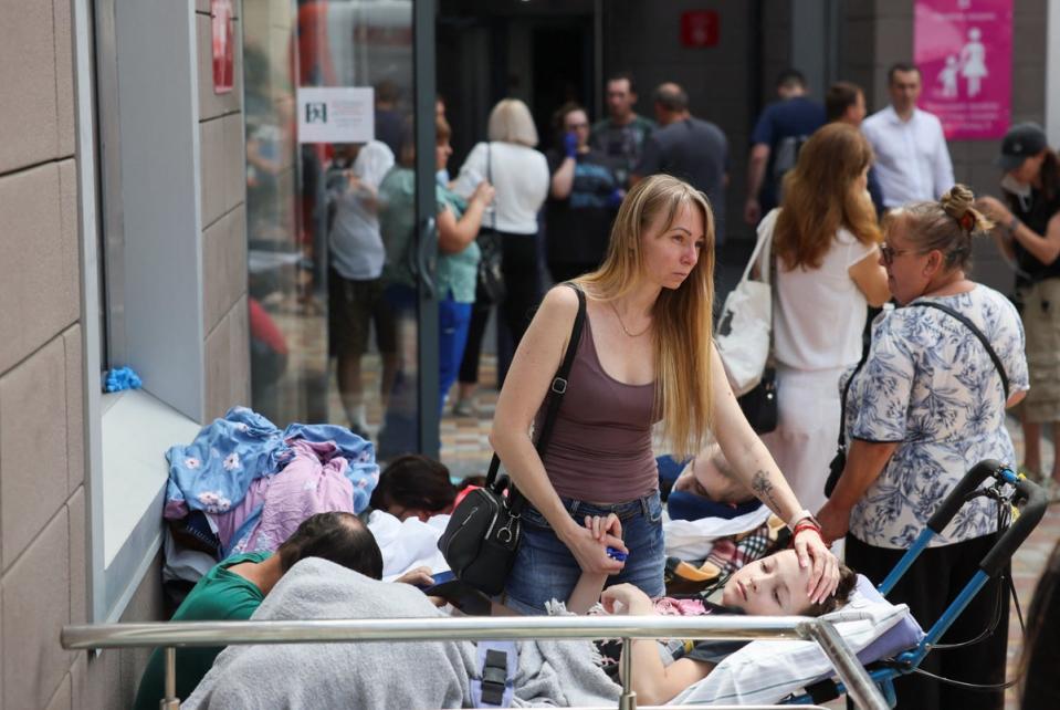 A woman touches a patient near Ohmatdyt Children's Hospital that was damaged during Russian missile strikes (REUTERS)