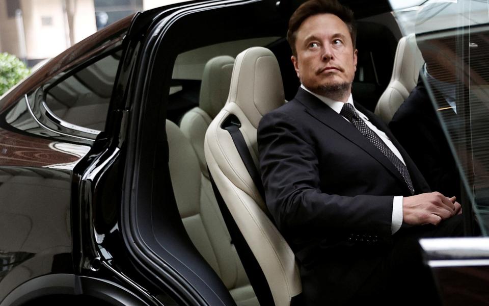 Elon Musk gets in a Tesla as he leaves a hotel in Beijing in May