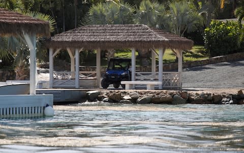 A man in a golf cart is seen at a dock in Little St. James Island, one of the properties of financier Jeffrey Epstein, near Charlotte Amalie - Credit: Reuters