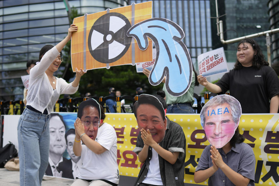 Students wearing masks of, from left, Japanese Prime Minister Fumio Kishida, South Korean President Yoon Suk Yeol and Rafael Mariano Grossi, director general of the International Atomic Energy Agency, perform during a rally to oppose Japanese government's plan to release treated radioactive water into the sea from the Fukushima nuclear power plant, in Seoul, South Korea, Friday, July 7, 2023. (AP Photo/Lee Jin-man)