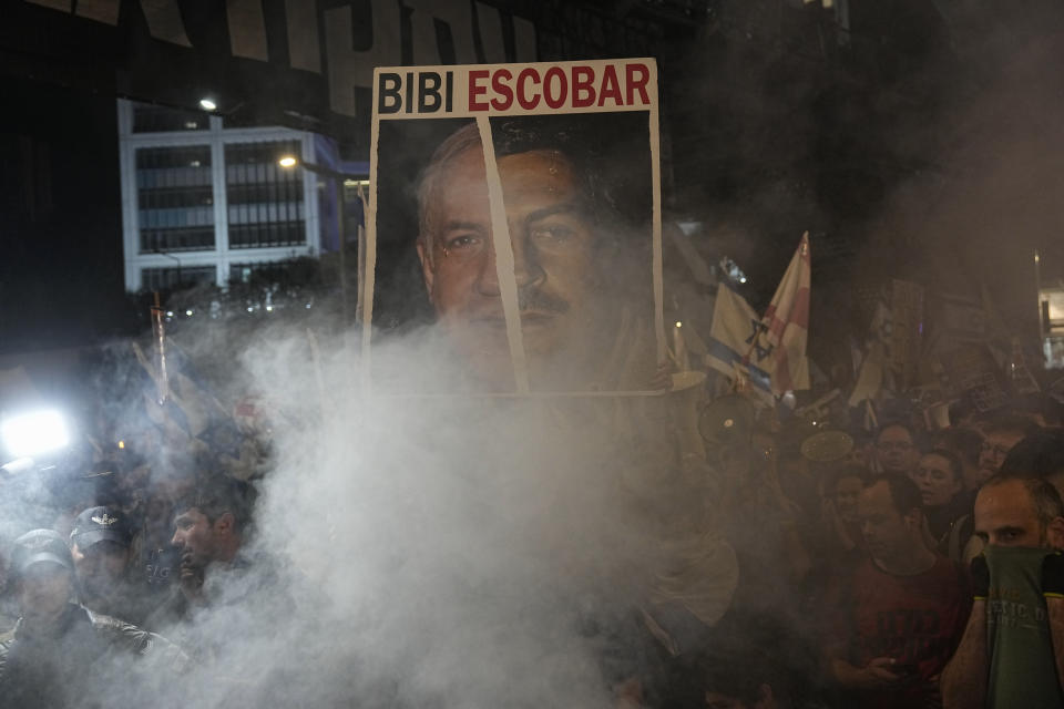 Un manifestante porta una pancarta en la que se compara al primer ministro israelí Benjamin Netanyahu con el capo de la droga colombiano Pablo Escobar, durante una protesta contra el gobierno de Netanyahu en Tel Aviv, Israel, el sábado 6 de abril de 2024. (AP Foto/Ariel Schalit)