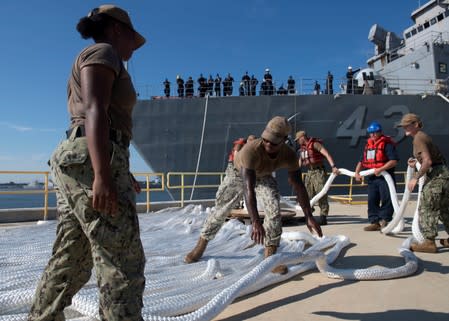 Sailors assigned to Naval Station Mayport lay down mooring lines as the amphibious dock landing ship USS Ft. McHenry is moved in preparation for Hurricane Dorian at Naval Station Mayport, in Jacksonville