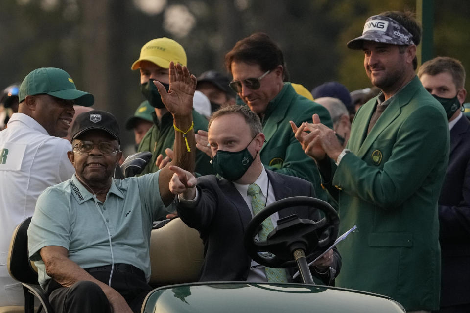 Lee Elder waves as he arrives for the ceremonial first tee shots before the first round of the Masters golf tournament on Thursday, April 8, 2021, in Augusta, Ga. Standing at right is Phil Mickelson and Bubba Watson. (AP Photo/Gregory Bull)